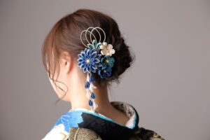 振袖に合わせたゆるふわシニヨンヘアスタイル。髪飾りは青色のつまみ細工